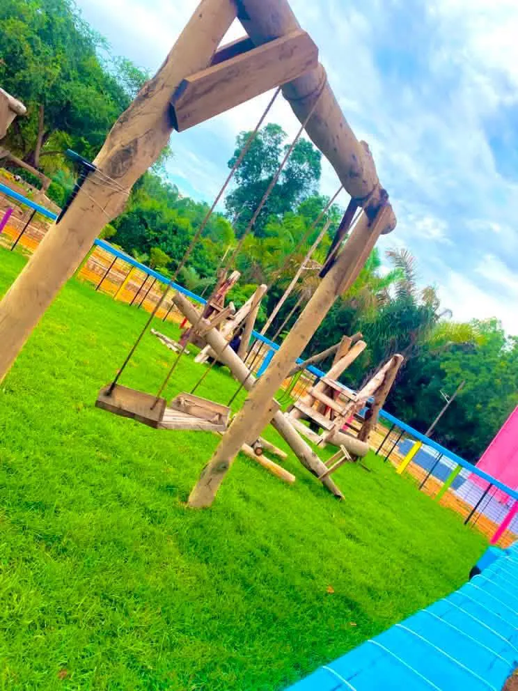 Children's playground with wooden swing set on the lawn